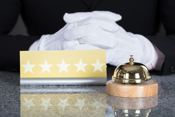 Waiter Near Service Bell And Five Star Shape Card