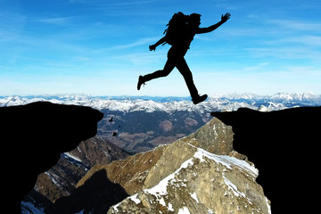 Man Jumping Over Rocky Mountain