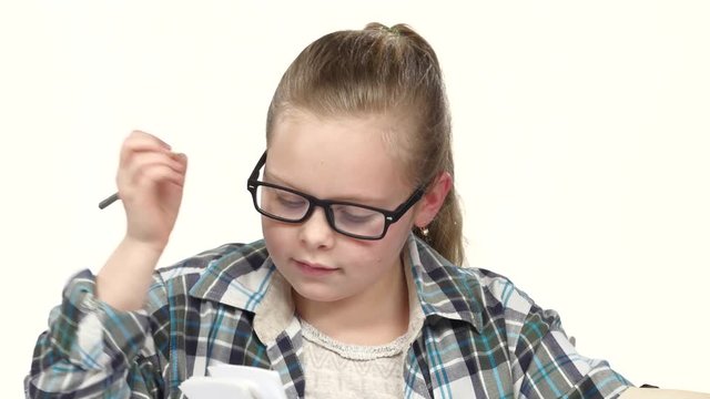 Girl carefully read and write data to the notebook. White background. Close up