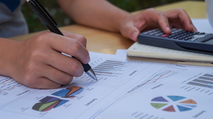 Closeup of hand man using calculator and calculate about cost at home office.