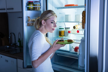 Suspicious Woman Taking Food From Fridge