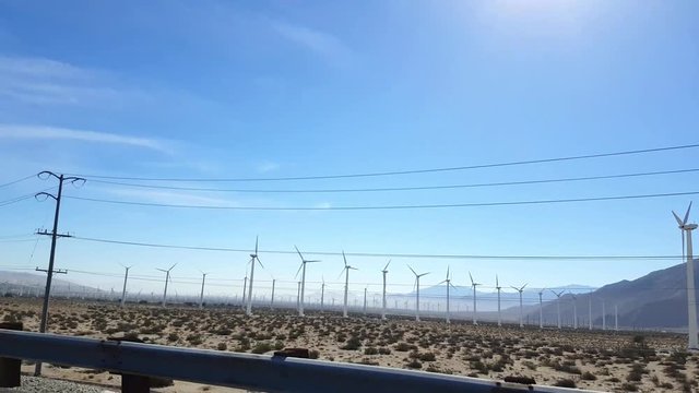 Driving by a field of wind power generators, on interstate 10, just outside Los angeles, california, in united states of america