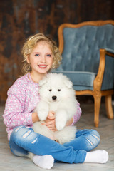 Little girl with a samoyed puppy