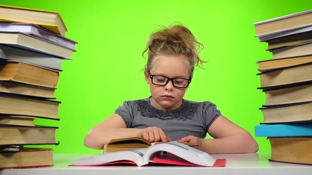 Girl reads the book closes it and takes another. Green screen. Slow motion