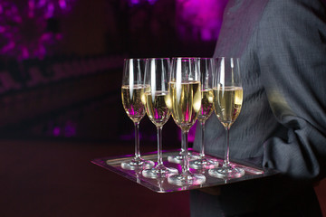 Waiter serving champagne on a tray
