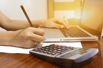 woman working with calculator, business document and laptop computer notebook,business  finance, selective focus