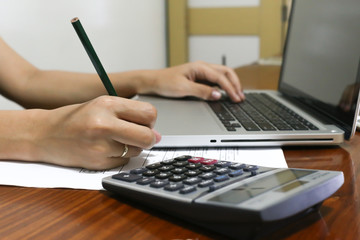 woman working with calculator, business document and laptop computer notebook,business  finance, selective focus