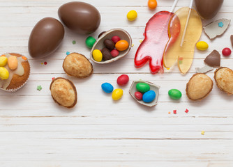 Chocolate Easter Eggs and Cupcake Over Wooden Background