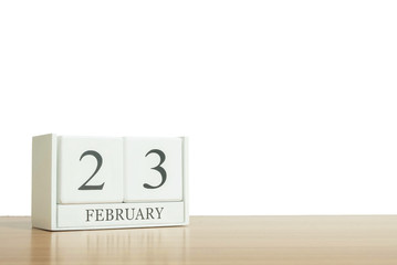 Closeup surface white wooden calendar with black 23 february word on blurred brown wood desk isolated on white background with copy space , selective focus at the calendar