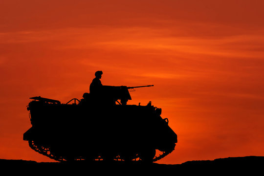 silhouette armored personnel carrier vehicle on sunset background.