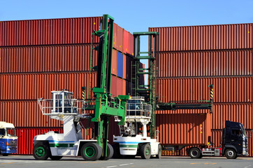 Toplifter handling cargo container loading to container trailer in import export logistic zone
