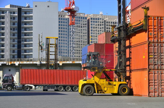 Toplifter handling cargo container loading to container trailer in import export logistic zone
