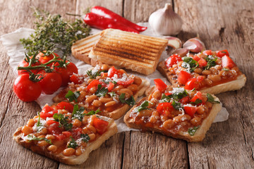 Healthy food: toast with white beans, tomatoes, cheese and garlic close-up. horizontal