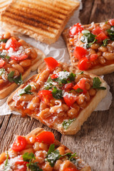 toast with white beans, tomatoes, cheese and herbs closeup. vertical