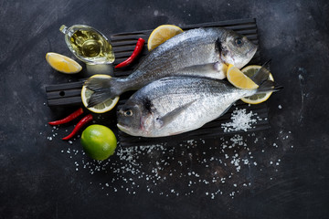 Fresh uncooked dorado on a dark metal background, above view