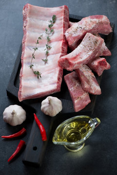 Wooden serving board with sliced, seasoned raw pork ribs