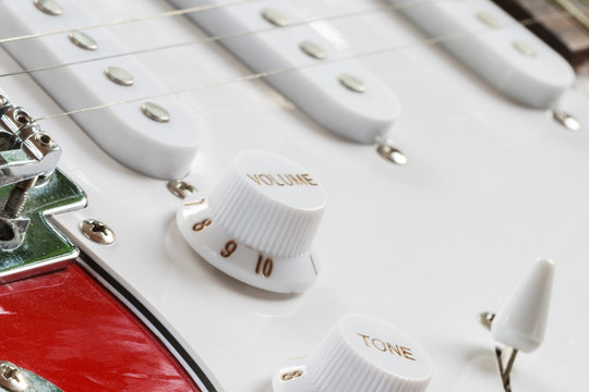 Bridge and metallic strings and tuner button of an electric guitar, Close-up picture.