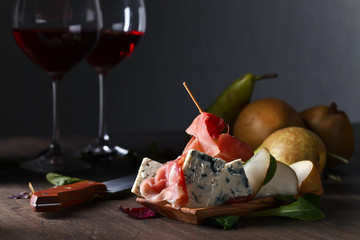 blue cheese with prosciutto , pear and red wine