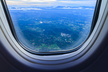 Landscape view of window at flying airplane.