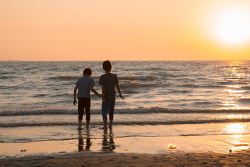 Fototapeta na wymiar Little boy playing at the beach sunset