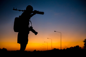 Fototapeta na wymiar silhouette of a photographer who shoots a sunset.