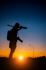 silhouette of a photographer who shoots a sunset.