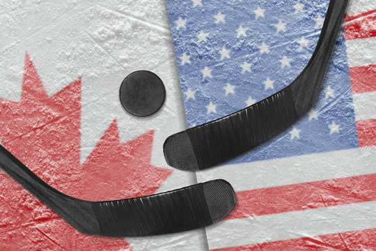 Canadian and American flags, and two hockey sticks hockey