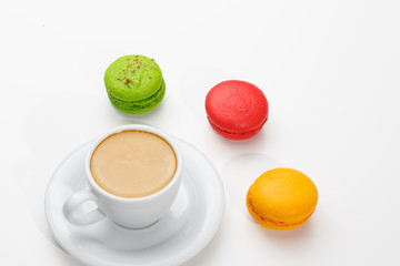 Macarons and a cup of expresso on white background. Conceptual, closeup.