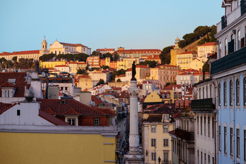 Sunset in Lisbon, Portugal. View on the colourful houses of historic centre, Rossio Square or Pedro IV Square and the monument column of Pedro IV