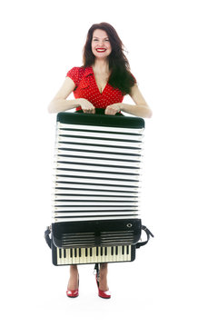 pretty brunette woman carries accordion on floor of studio with white background