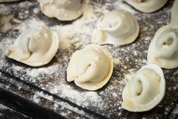 Traditional pelmeni or dumpling at cutting board.