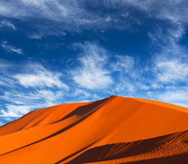 Sand dunes on blue sky background in Sahara desert in Morocco, Africa