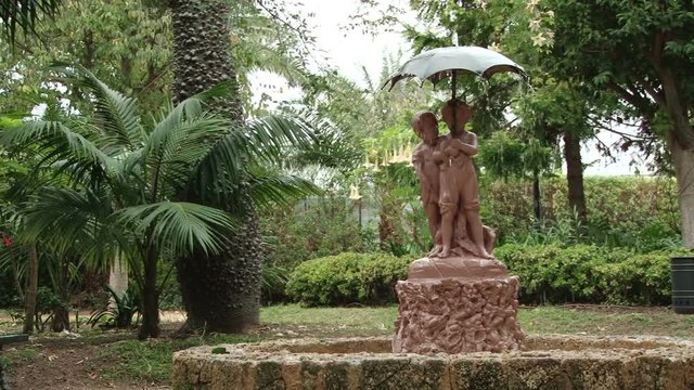 Fountain if two children under an umbrella in Parque Genoves in Cadiz Spain.