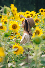 Young girl in a hat on a field of sunflowers
