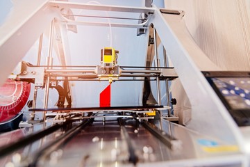 3d printer printing red plastic component