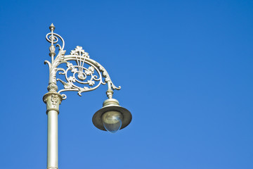 Fototapeta na wymiar Typical classic Irish streetlight against a blue background - image with copy space
