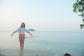 Obraz premium Happy woman standing arms outstretched and enjoy life on the beach at Sea