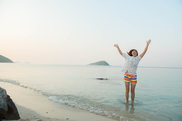 Fototapeta na wymiar young woman happy jumping on the beach