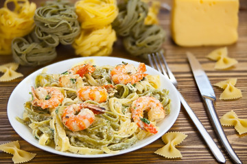 delicious fettuccine pasta with prawns on white plate
