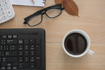 Business Objects in the office . cup coffee and keyboard on wooden table .