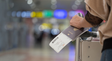 Closeup of girl  holding passports and boarding pass at airport - obrazy, fototapety, plakaty
