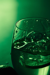 Green alcohol drink in glass with ice