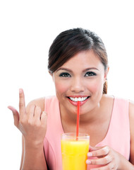 Young woman sipping orange juice on white background