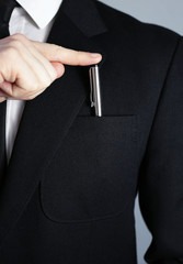 putting pen in his jacket. Black business suit