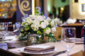 Bouquet of white roses on table.Selective focus/Decor on a table in a restaurant - bouquet of white roses on decorated table in restaurant