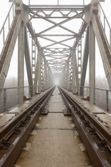 railroad goes into the mist. gray misty autumn morning.