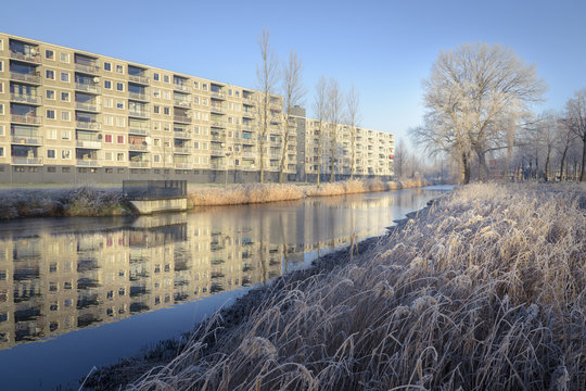 White urban winter landscape with water and flat