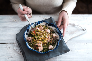 Woman eating a salad with chicken and beans for white table