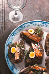 Sardines, quail egg on rye bread and the glass