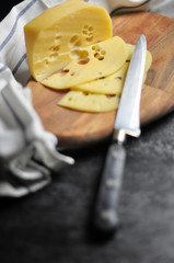Yellow cheese on a wooden cutting board